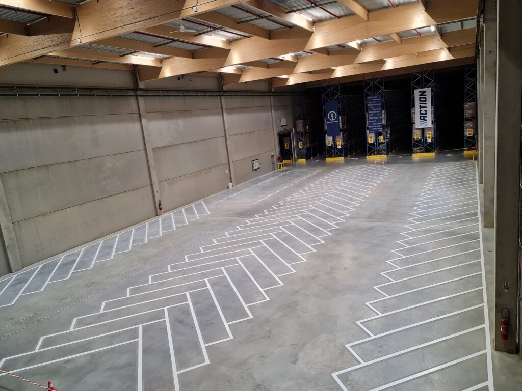Marquage au sol blanc en chevrons dans un entrepôt logistique de 1 000 m².