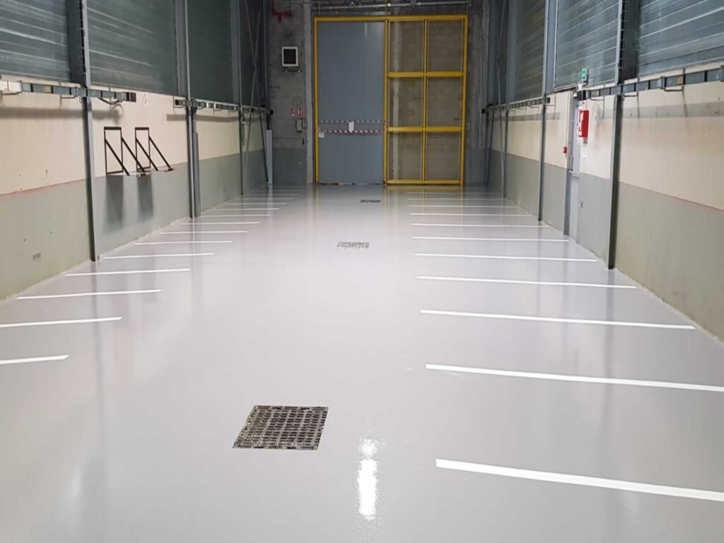 Revêtement de sol industriel en résine époxy gris clair avec marquage au sol sur 300 m².