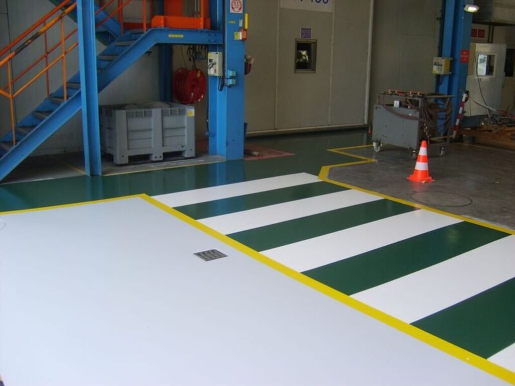 Marquage piéton blanc et vert sur sol en résine époxy dans un entrepôt de stockage de 400 m².