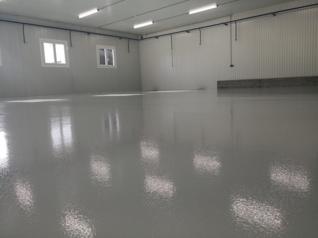 Sol en résine époxy gris brillant sur 250 m² dans une salle de réception.