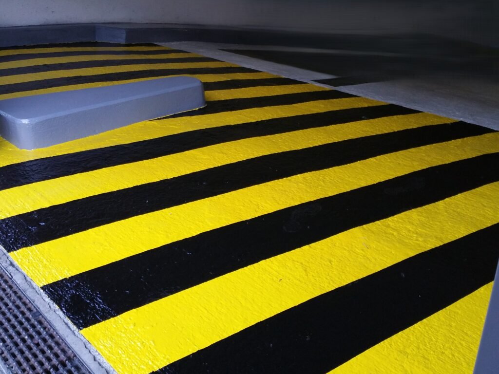 Marquage au sol jaune et noir à l’entrée d’un parking sur plusieurs niveaux, avec signalisation blanche sur 2 000 m².